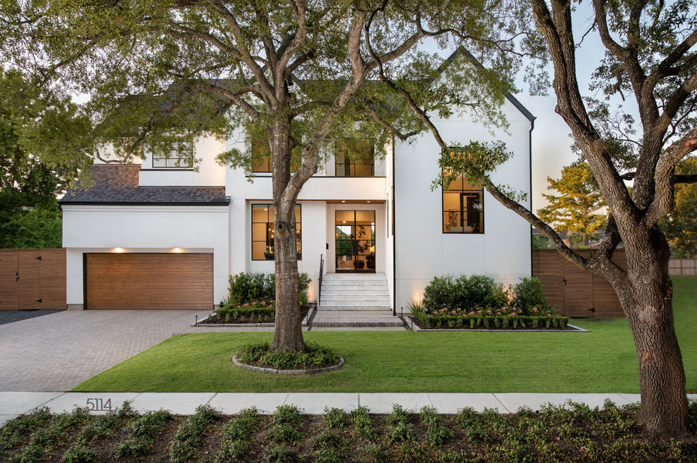 This is an example of a transitional two-storey white house exterior in Houston with a gable roof and a shingle roof.