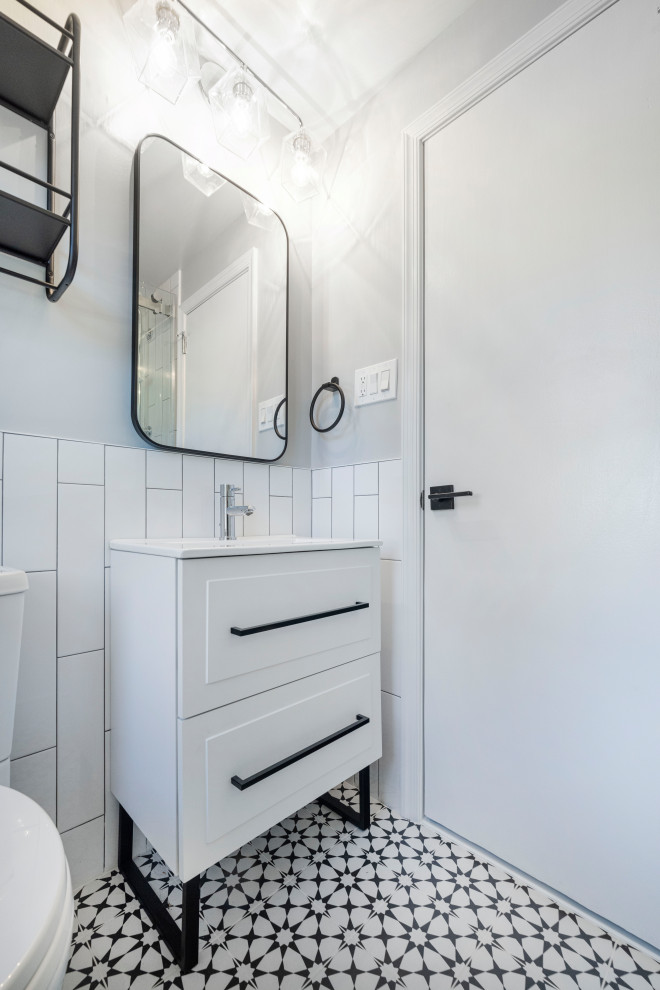 Пример оригинального дизайна: маленькая ванная комната в стиле ретро с фасадами островного типа, белыми фасадами, душем в нише, раздельным унитазом, белой плиткой, плиткой кабанчик, серыми стенами, полом из керамогранита, душевой кабиной, накладной раковиной, столешницей из искусственного камня, черным полом, душем с раздвижными дверями, белой столешницей, нишей, тумбой под одну раковину, напольной тумбой и панелями на стенах для на участке и в саду