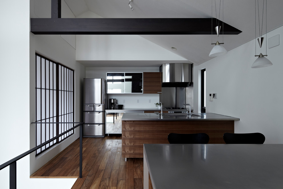 Design ideas for a modern galley eat-in kitchen in Tokyo with an integrated sink, stainless steel cabinets, stainless steel benchtops, grey splashback, stainless steel appliances, dark hardwood floors, with island, brown floor and grey benchtop.