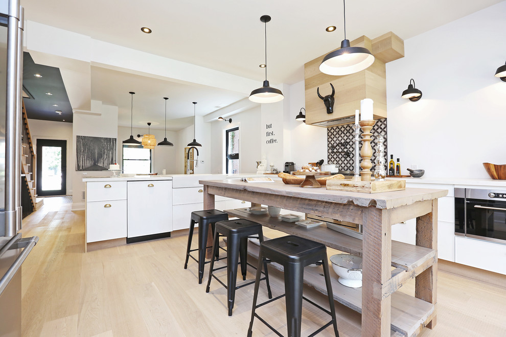 Photo of a large scandinavian open plan kitchen in Toronto with a farmhouse sink, flat-panel cabinets, white cabinets, quartzite benchtops, multi-coloured splashback, ceramic splashback, stainless steel appliances, light hardwood floors and with island.