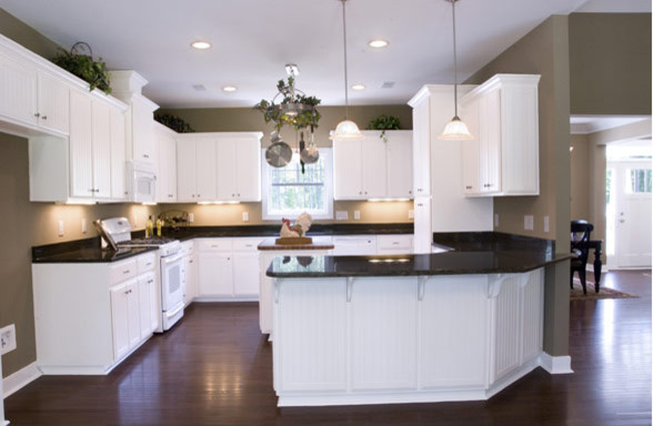 Open concept kitchen - mid-sized transitional l-shaped dark wood floor and brown floor open concept kitchen idea with white cabinets, quartz countertops, white appliances, an island and black countertops