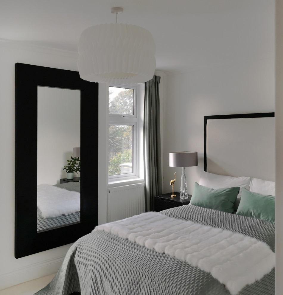 Design ideas for a medium sized modern guest bedroom in London with white walls, carpet and white floors.