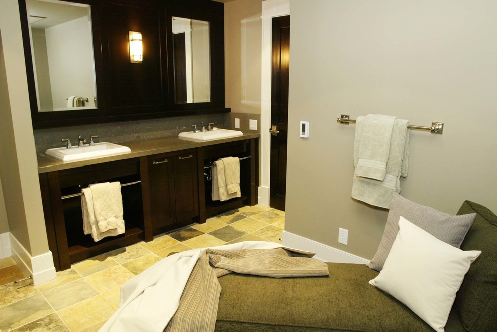 Photo of a large master bathroom in Calgary with a drop-in sink, flat-panel cabinets, dark wood cabinets, quartzite benchtops, beige tile, beige walls and slate floors.