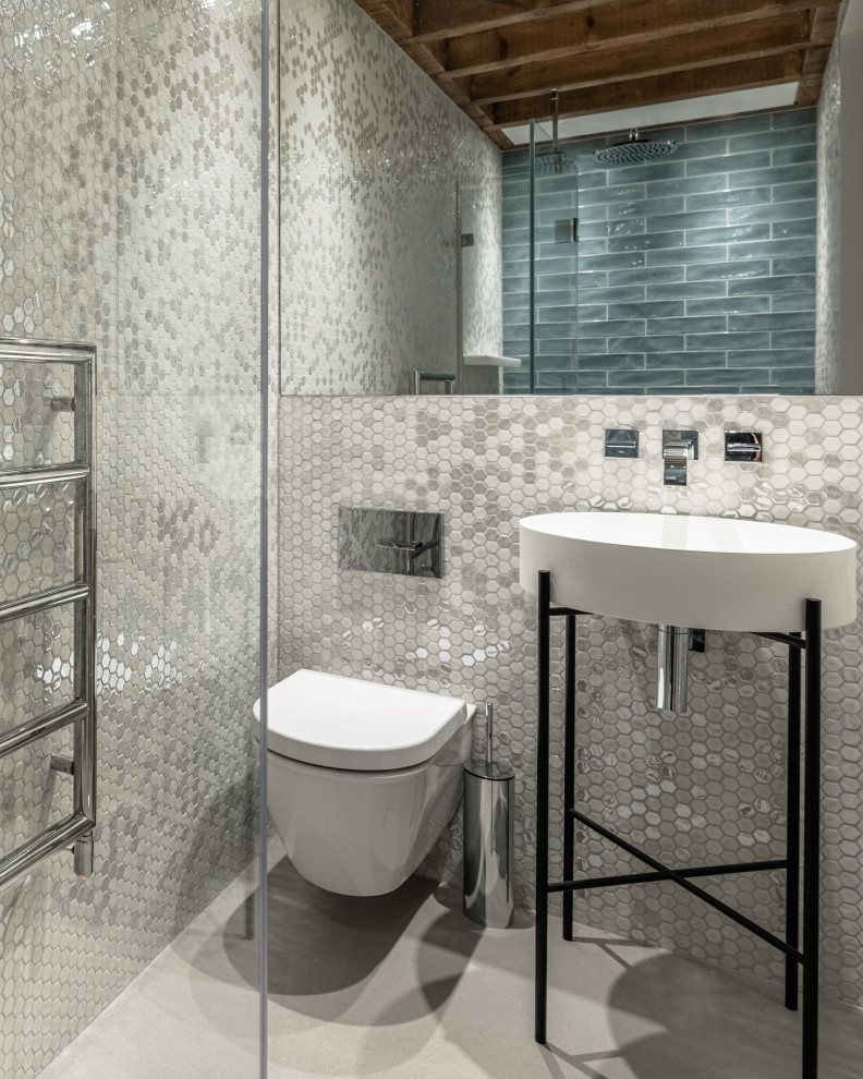 Modelo de cuarto de baño único contemporáneo con sanitario de pared, baldosas y/o azulejos grises, lavabo tipo consola, suelo gris y vigas vistas