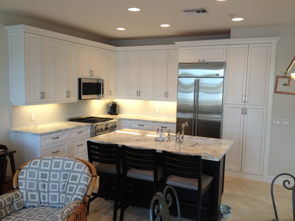 Open concept kitchen - mid-sized transitional u-shaped travertine floor and beige floor open concept kitchen idea in Miami with an undermount sink, shaker cabinets, white cabinets, marble countertops, multicolored backsplash, glass tile backsplash, stainless steel appliances and an island