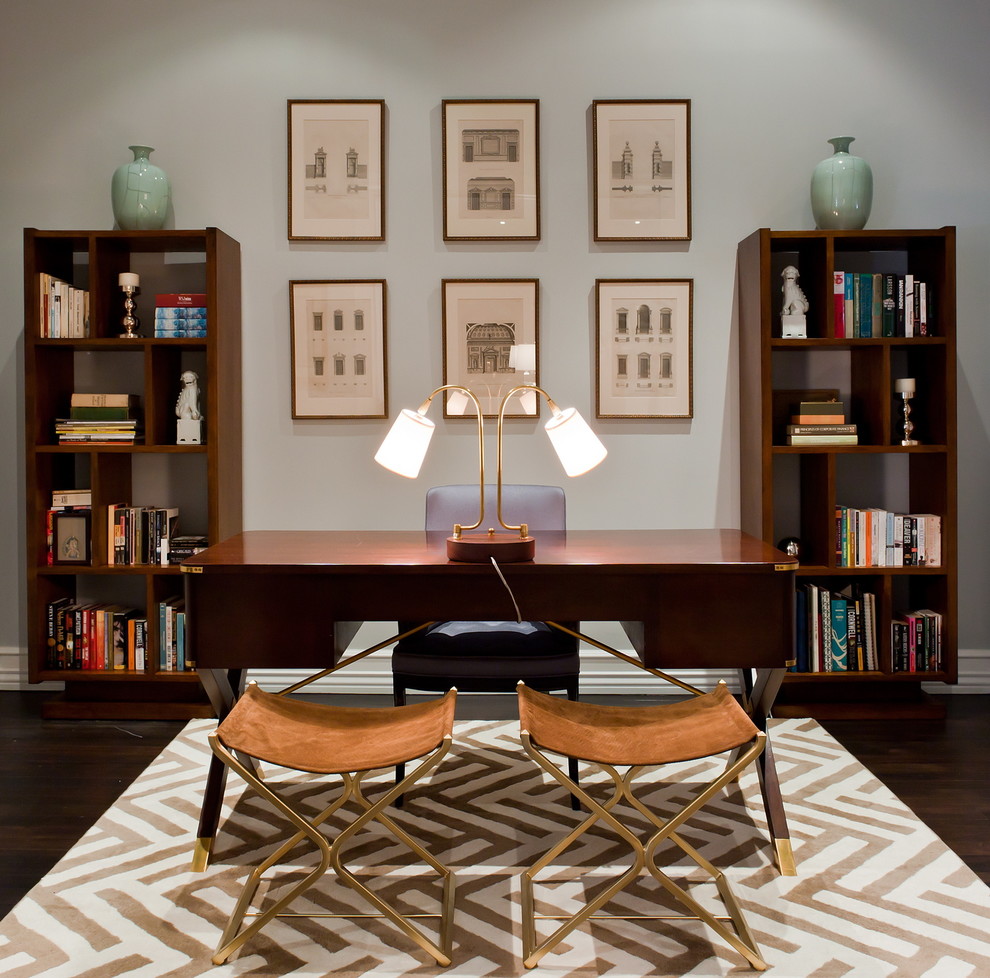 This is an example of a mid-sized transitional study room in New York with grey walls, dark hardwood floors, a freestanding desk and no fireplace.