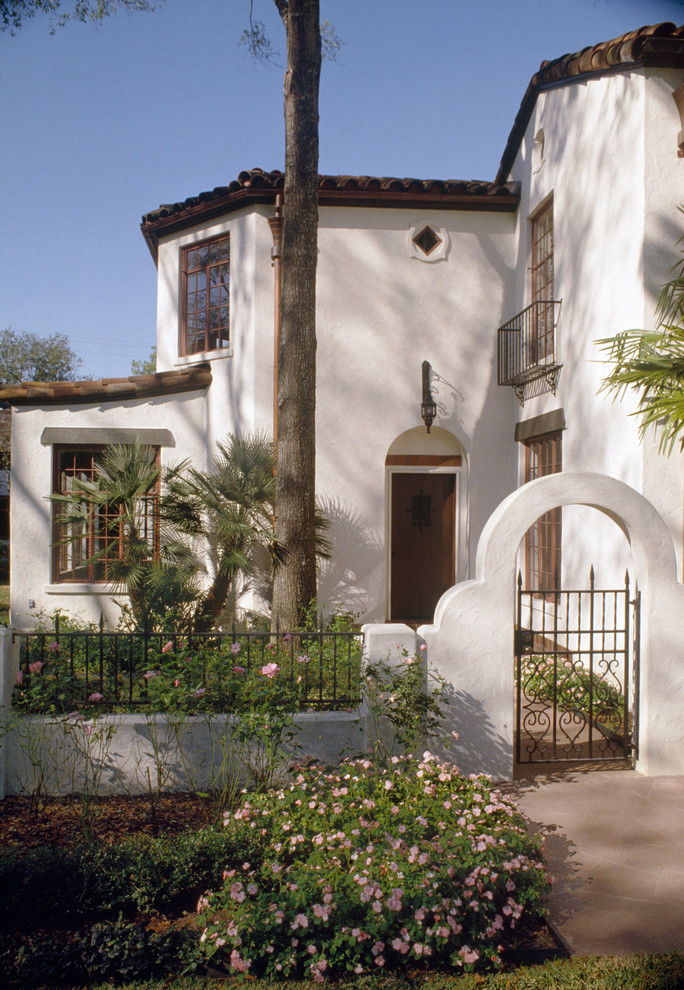 Inspiration for a large mediterranean two-storey stucco white exterior in Houston with a gable roof.