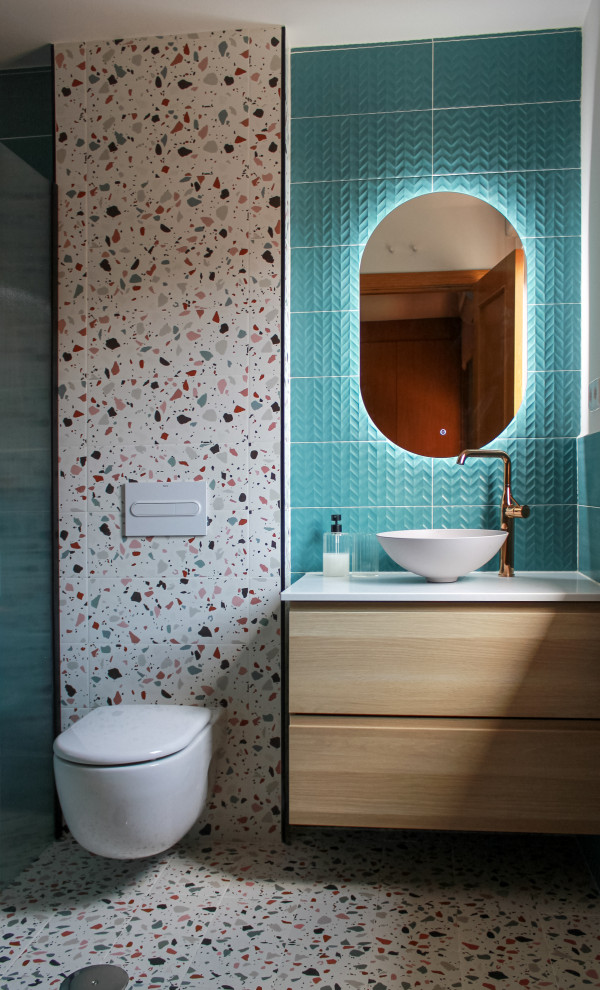 Bild på ett litet funkis en-suite badrum, med en kantlös dusch, en vägghängd toalettstol, blå kakel, keramikplattor, grå väggar, klinkergolv i keramik, ett fristående handfat och med dusch som är öppen
