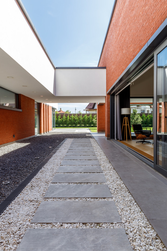 Photo of a contemporary courtyard partial sun garden for summer in Other with gravel and a garden path.