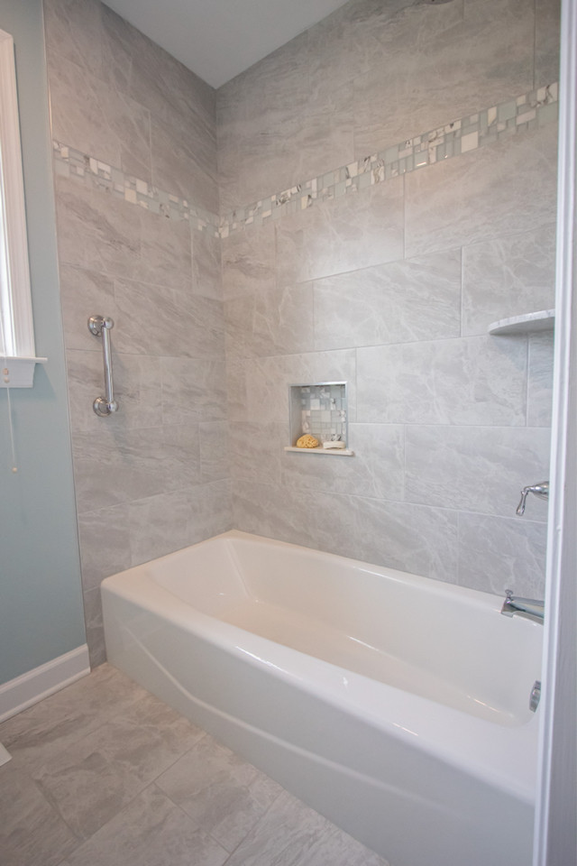 Klassisk inredning av ett litet grå grått badrum, med vita skåp, ett badkar i en alkov, en dusch/badkar-kombination, en toalettstol med separat cisternkåpa, porslinskakel, blå väggar, klinkergolv i porslin, ett undermonterad handfat, bänkskiva i kvarts, grått golv och dusch med duschdraperi