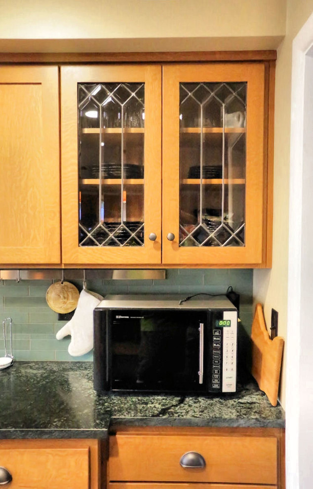 This is an example of a traditional kitchen in San Diego with glass-front cabinets.