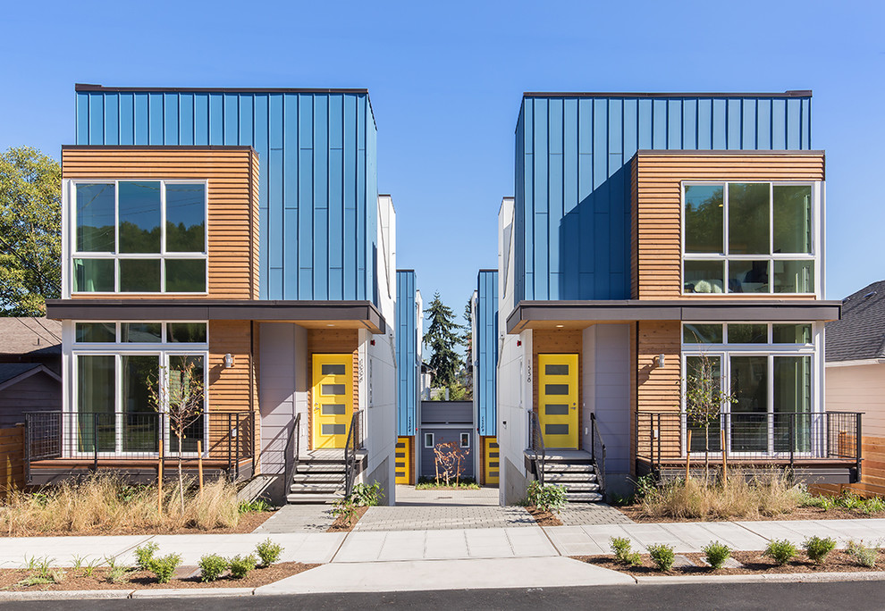Inspiration for a contemporary multi-coloured townhouse exterior in Seattle with mixed siding and a flat roof.