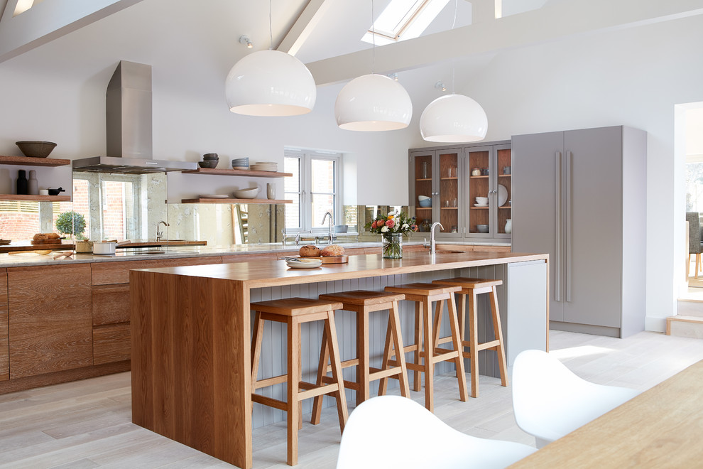 Inspiration for a large contemporary l-shaped eat-in kitchen in Other with grey cabinets, wood benchtops, panelled appliances, light hardwood floors, with island, open cabinets, window splashback and beige floor.