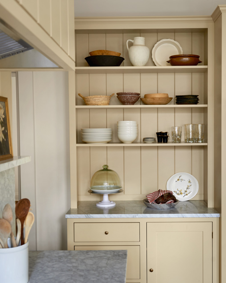 Exempel på ett mellanstort klassiskt grå grått kök och matrum, med skåp i shakerstil, gula skåp, marmorbänkskiva, grått stänkskydd, stänkskydd i marmor, vita vitvaror, mellanmörkt trägolv och brunt golv