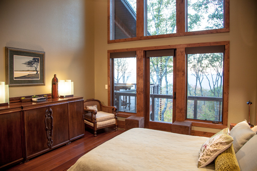 This is an example of a large contemporary master bedroom in Other with beige walls, dark hardwood floors, a corner fireplace and brown floor.