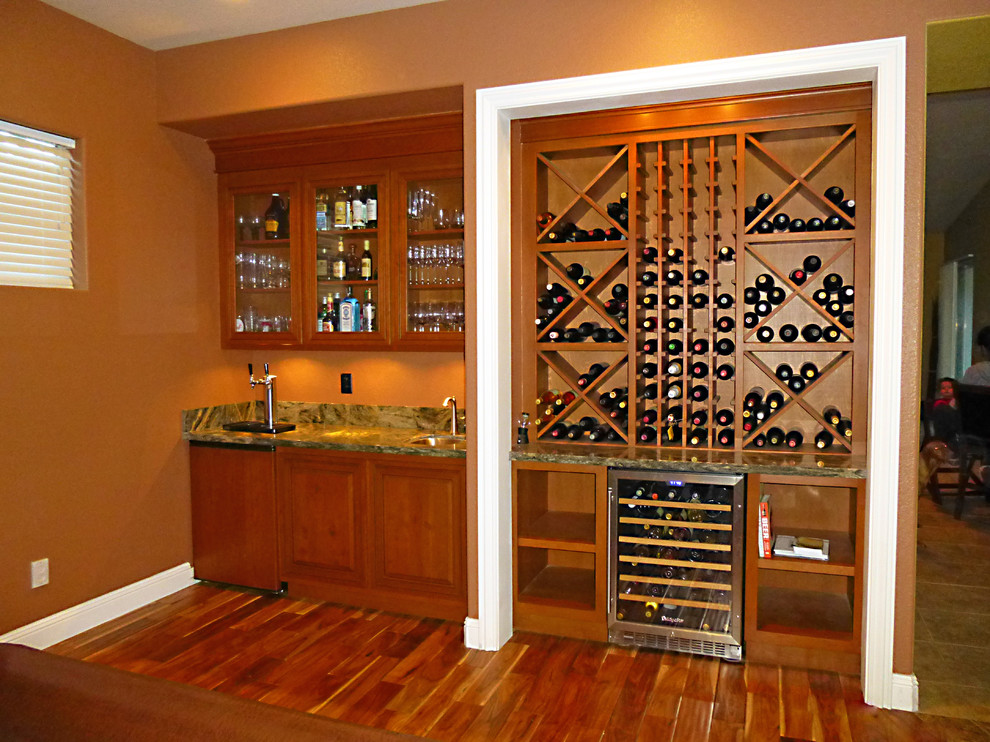 Photo of a mid-sized traditional wine cellar in Other with medium hardwood floors and diamond bins.