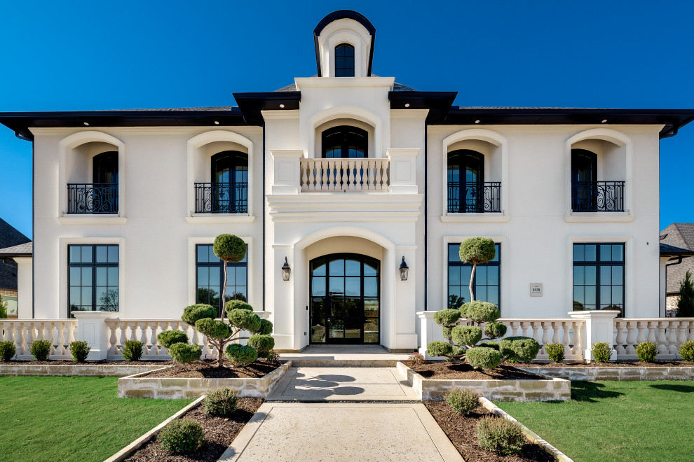 Photo of a large mediterranean two-storey stucco white exterior in Dallas.