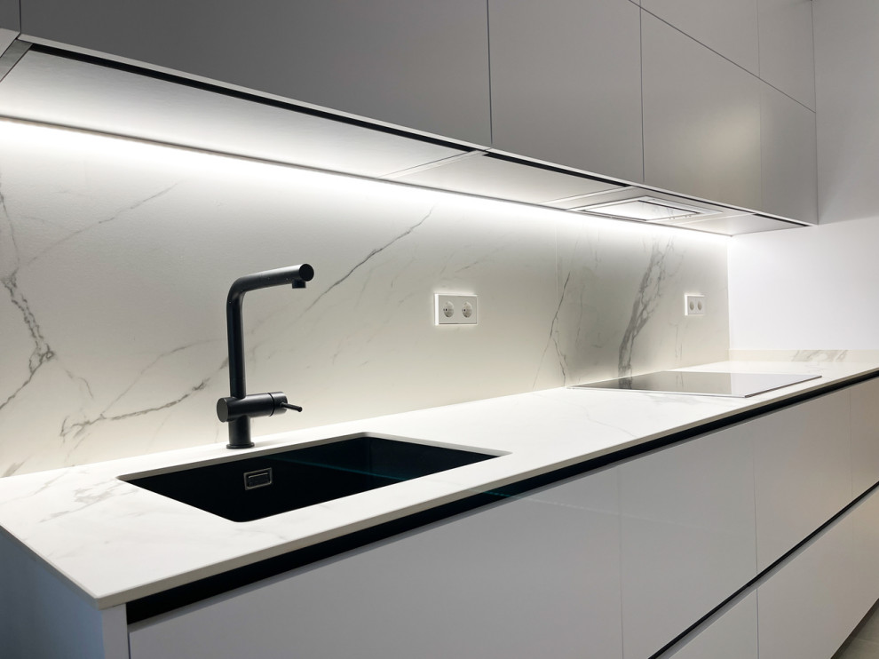 Inspiration for a medium sized modern enclosed kitchen in Madrid with a submerged sink, marble worktops, white splashback, marble splashback, stainless steel appliances, no island and white worktops.