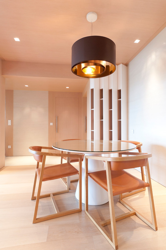 Inspiration for a modern dining room in Singapore with white walls and light hardwood floors.