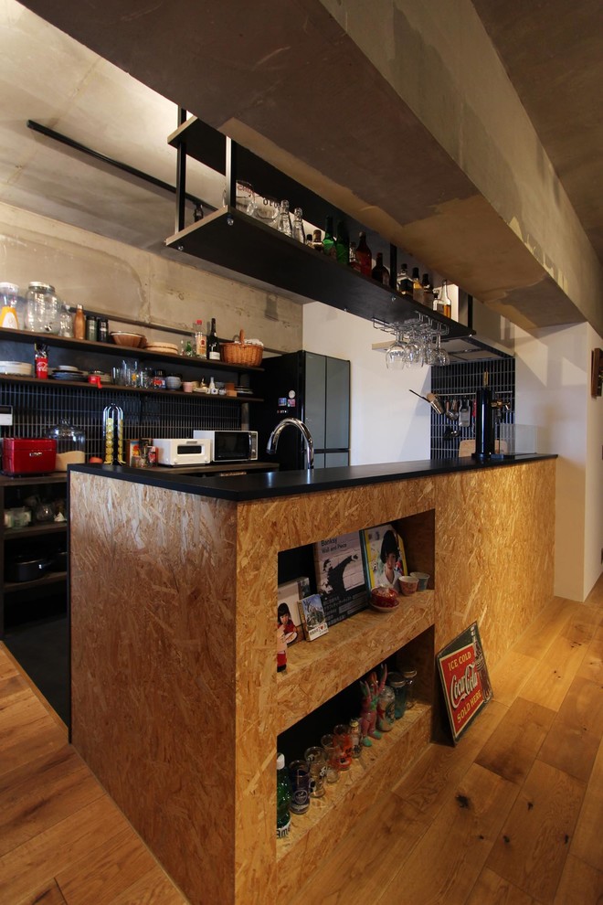 This is an example of an industrial kitchen in Tokyo with medium hardwood floors, with island and brown floor.