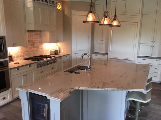 Example of a mid-sized transitional l-shaped kitchen design in Austin with an undermount sink, shaker cabinets, white cabinets, stainless steel appliances and an island