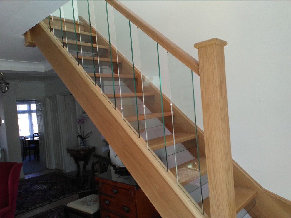 Transitional wood l-shaped staircase in Cheshire with glass risers and glass railing.