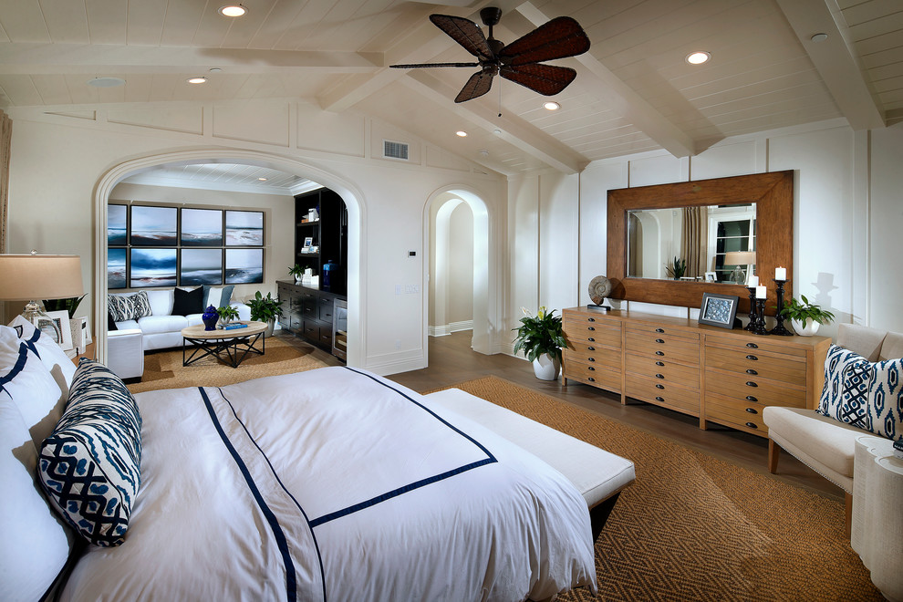Inspiration for an expansive beach style master bedroom in San Diego with white walls and light hardwood floors.