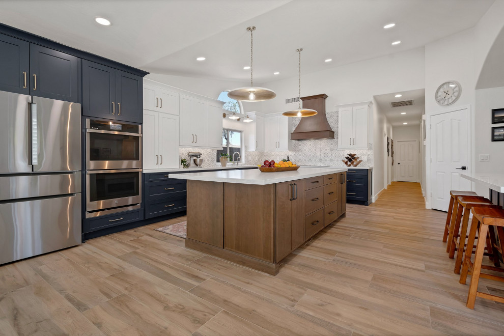 Eat-in kitchen - large transitional l-shaped porcelain tile, brown floor and vaulted ceiling eat-in kitchen idea in Phoenix with an undermount sink, shaker cabinets, blue cabinets, quartzite countertops, multicolored backsplash, mosaic tile backsplash, stainless steel appliances, two islands and white countertops