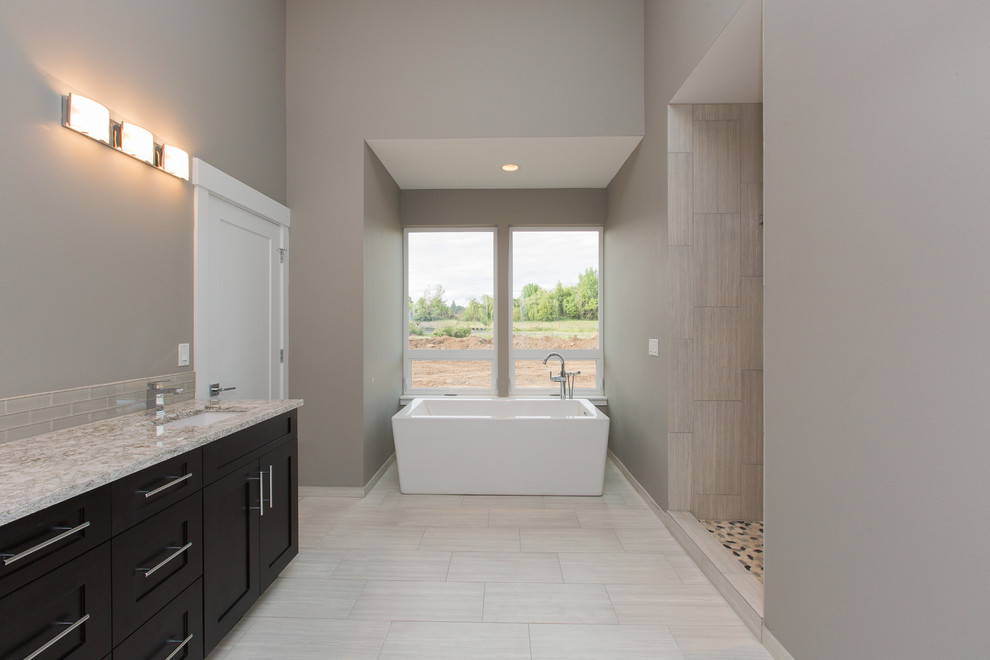 Inspiration for a large contemporary master bathroom in Portland with shaker cabinets, white cabinets, a freestanding tub, an alcove shower, a one-piece toilet, gray tile, ceramic tile, grey walls, ceramic floors, a console sink and tile benchtops.