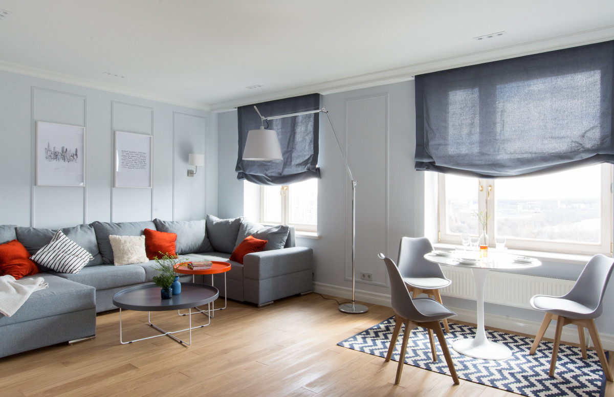 Scandinavian formal open concept living room in Moscow with grey walls and light hardwood floors.