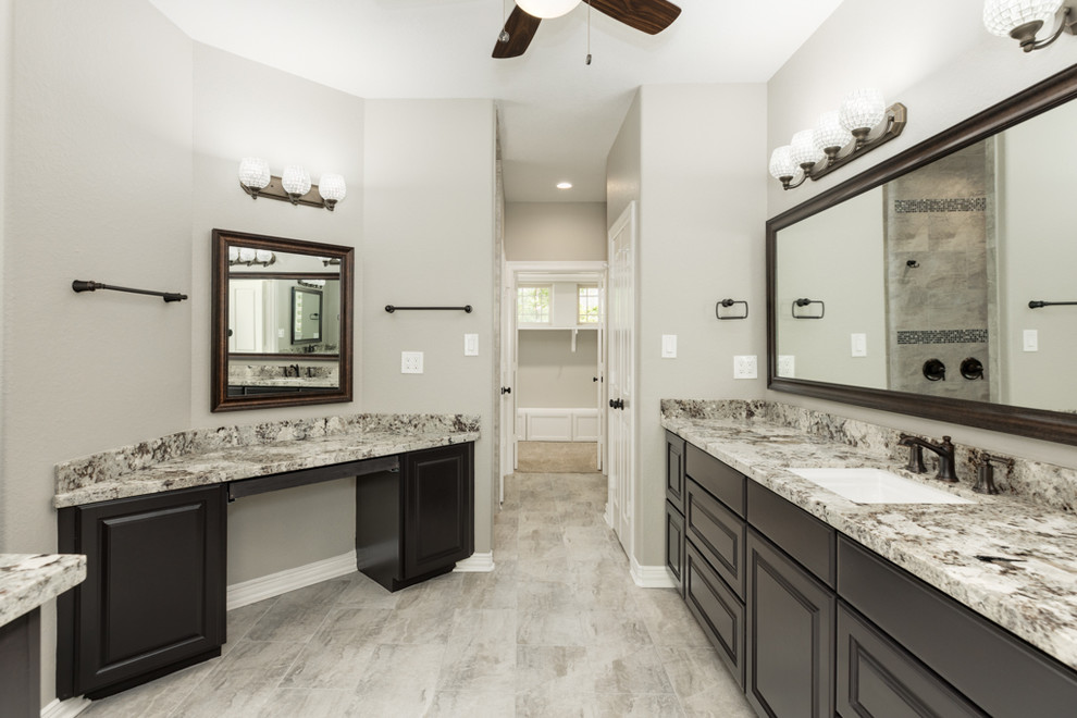 This is an example of an expansive arts and crafts master bathroom in Houston with raised-panel cabinets, brown cabinets, beige tile, granite benchtops, an open shower, a two-piece toilet, beige walls, porcelain floors, an undermount sink, grey floor and an open shower.