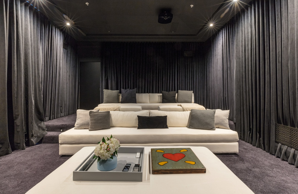 Transitional enclosed home theatre in Los Angeles with carpet, a projector screen and grey floor.