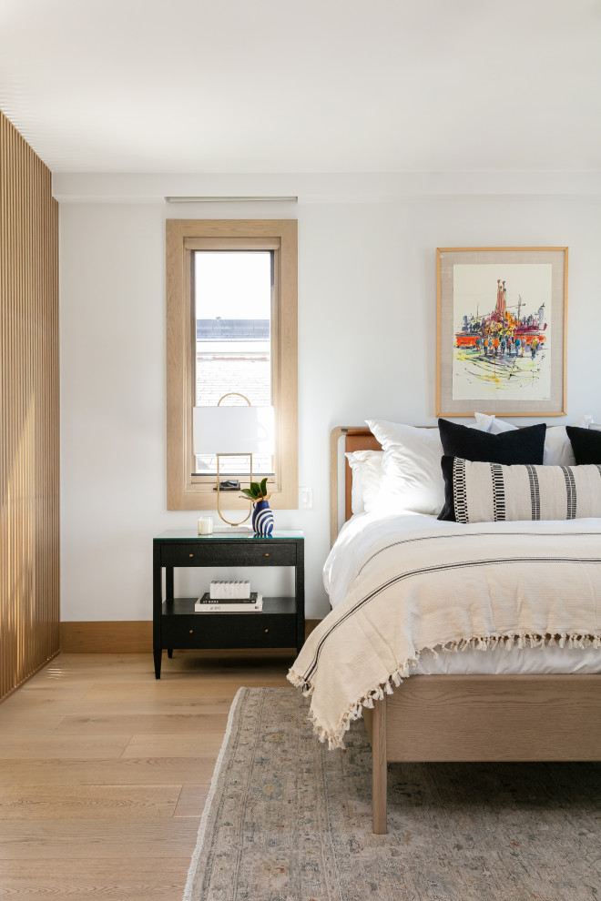 Ejemplo de dormitorio clásico renovado con paredes blancas, suelo de madera clara y suelo beige