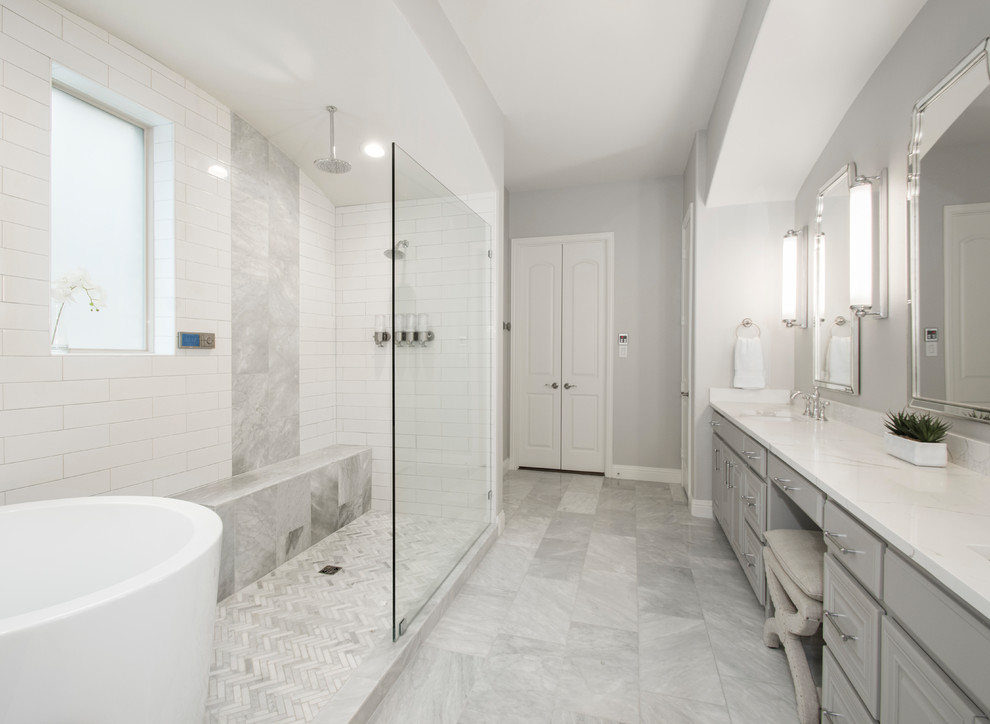Photo of a mid-sized transitional master bathroom in Dallas with raised-panel cabinets, grey cabinets, a japanese tub, an open shower, a two-piece toilet, beige tile, ceramic tile, beige walls, marble floors, an undermount sink, engineered quartz benchtops, grey floor, an open shower and white benchtops.