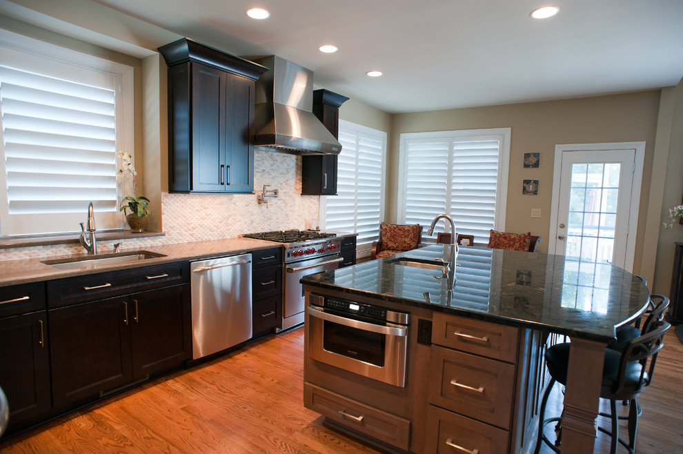 Mid-sized transitional l-shaped kitchen photo in Charlotte with dark wood cabinets, granite countertops, white backsplash and an island