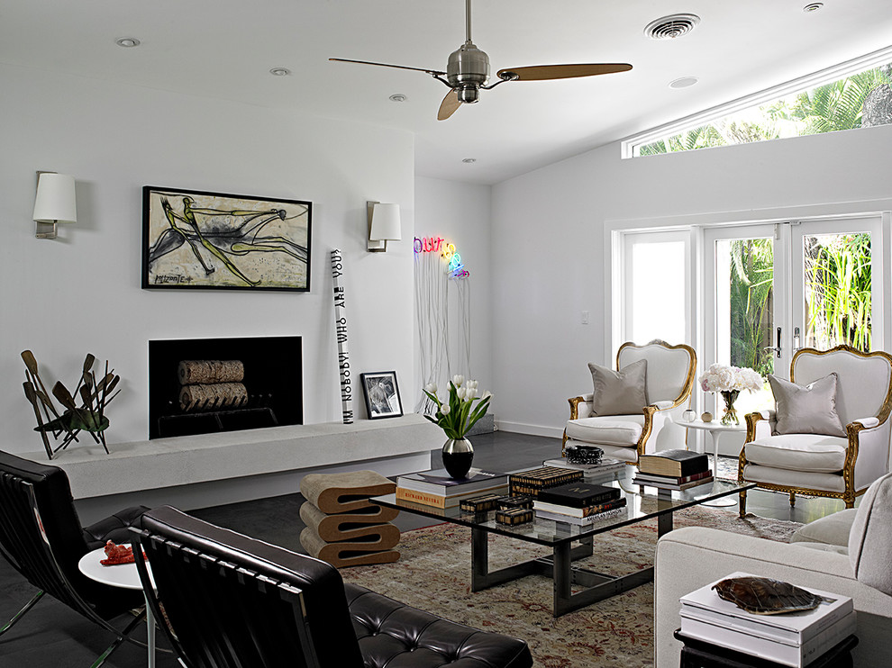 This is an example of a contemporary formal living room in Miami with white walls, a ribbon fireplace and black floor.