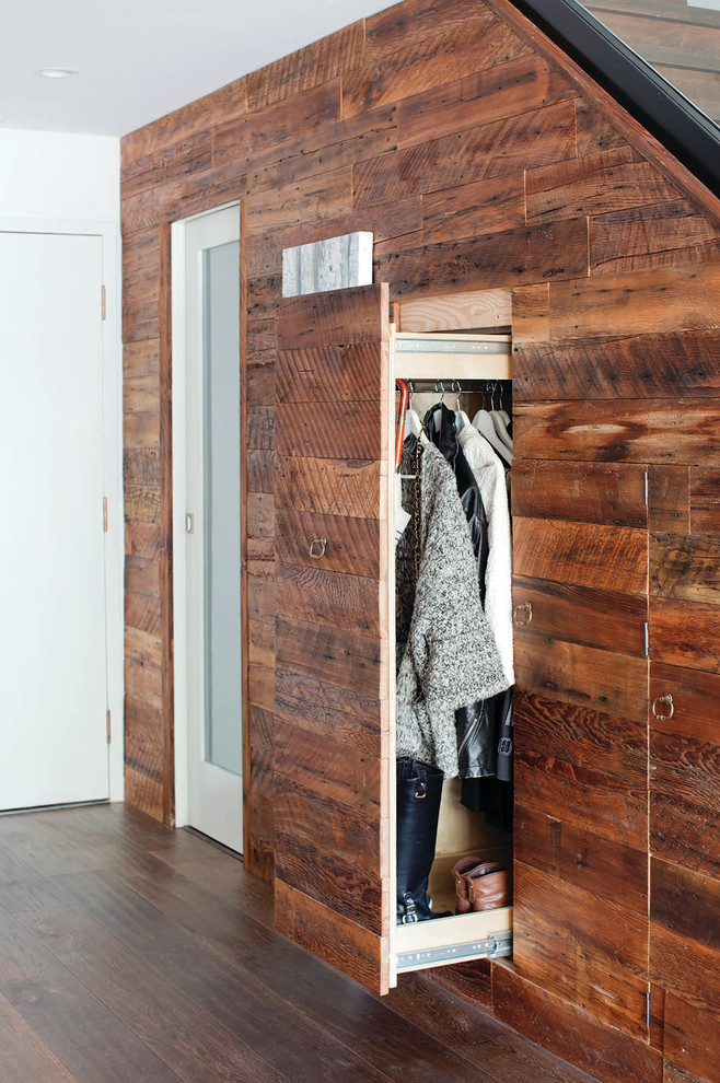 Design ideas for a contemporary gender-neutral built-in wardrobe in Vancouver with flat-panel cabinets, dark wood cabinets and dark hardwood floors.