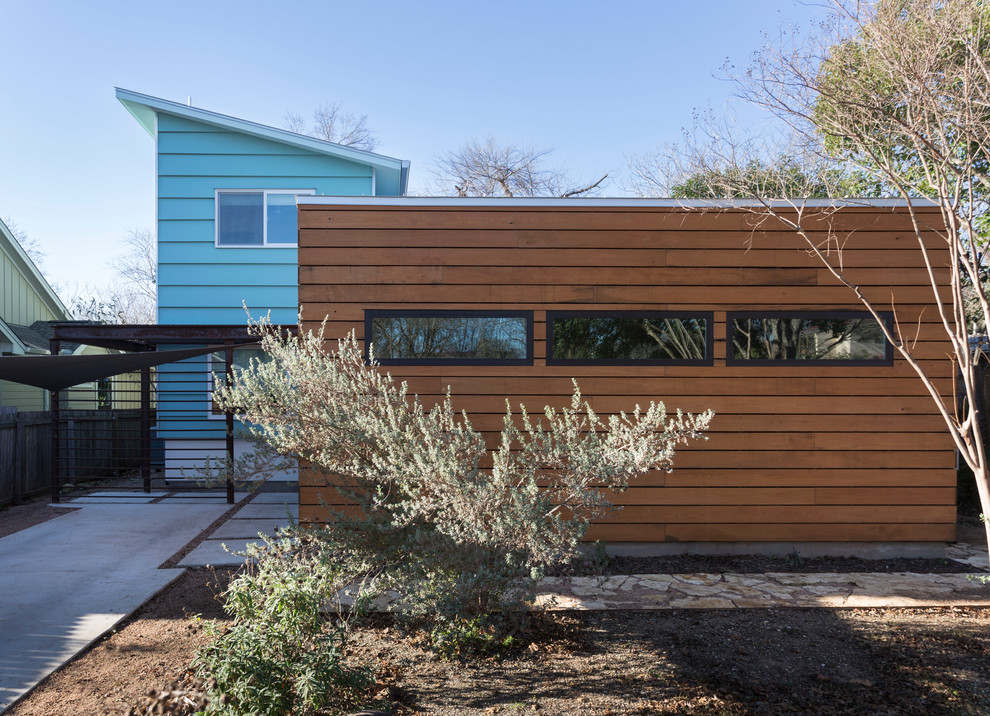Photo of a contemporary two-storey exterior in Austin with wood siding.