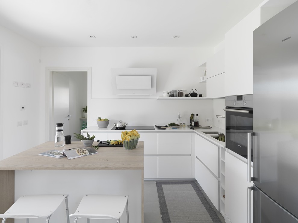 Inspiration for a mid-sized contemporary l-shaped open plan kitchen in Other with a double-bowl sink, flat-panel cabinets, white cabinets, solid surface benchtops, white splashback, stainless steel appliances and with island.