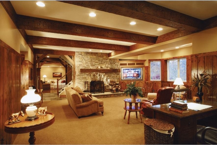 Large country enclosed living room in Cleveland with beige walls, carpet, a standard fireplace, a stone fireplace surround and a built-in media wall.