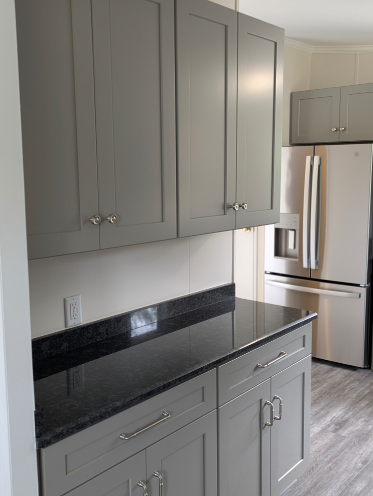 Enclosed kitchen - small transitional l-shaped gray floor enclosed kitchen idea with a single-bowl sink, flat-panel cabinets, gray cabinets, granite countertops, stainless steel appliances and black countertops