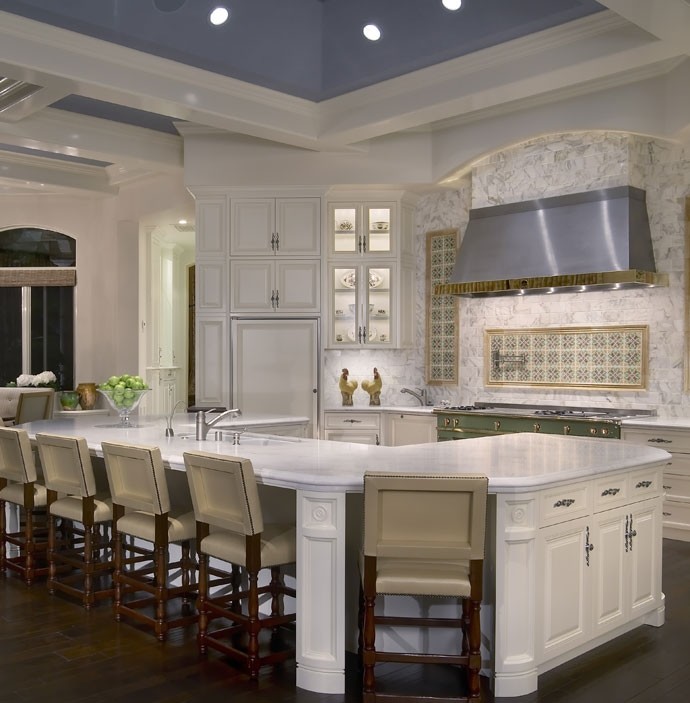 Design ideas for a mediterranean eat-in kitchen in San Diego with white cabinets, stainless steel appliances, dark hardwood floors and a peninsula.
