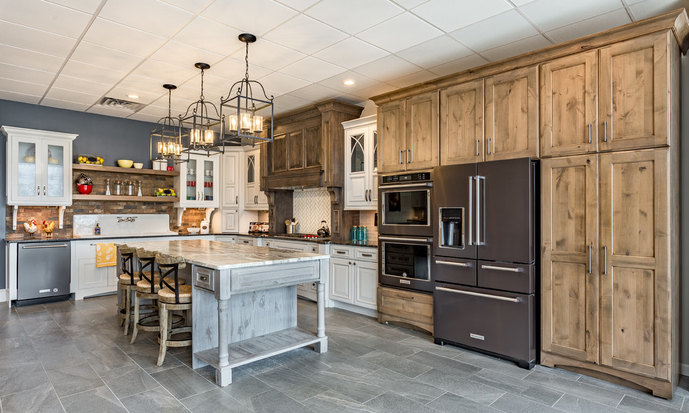 Open concept kitchen - large transitional l-shaped gray floor open concept kitchen idea with a drop-in sink, shaker cabinets, medium tone wood cabinets, granite countertops, white backsplash, subway tile backsplash, stainless steel appliances and an island