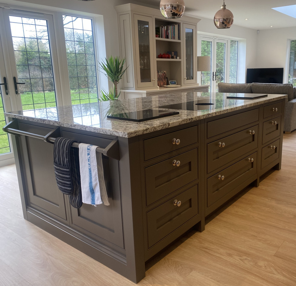 Expansive arts and crafts u-shaped kitchen in Sussex with a double-bowl sink, shaker cabinets, beige cabinets, white splashback, shiplap splashback, black appliances, linoleum floors, with island, brown floor and white benchtop.