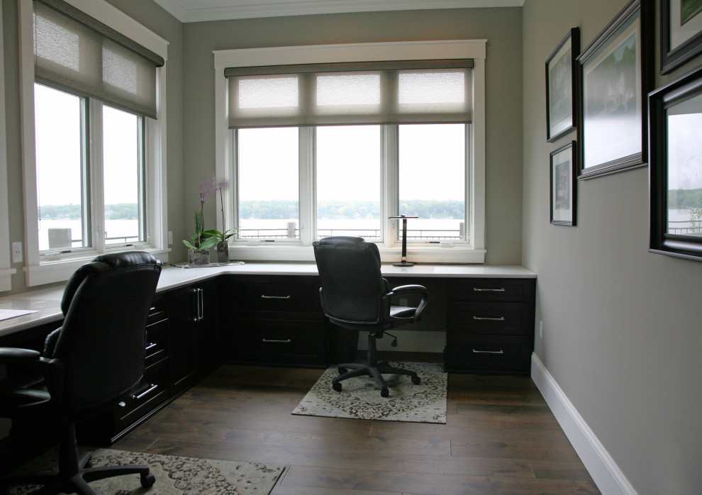 Large elegant built-in desk medium tone wood floor and brown floor home studio photo in Milwaukee with gray walls