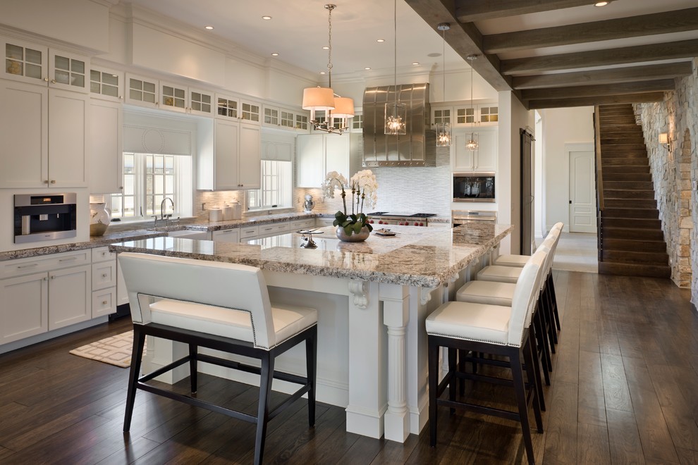 Inspiration for a huge transitional u-shaped dark wood floor open concept kitchen remodel in Orlando with shaker cabinets, white cabinets, white backsplash, stainless steel appliances and an island