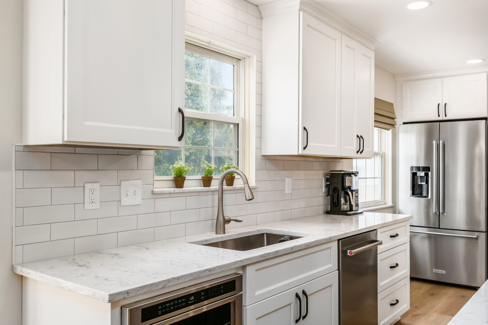 Inspiration for a large transitional l-shaped eat-in kitchen in Raleigh with quartz benchtops and with island.