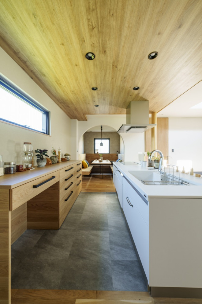 Medium sized world-inspired single-wall kitchen/diner in Other with an integrated sink, composite countertops, white splashback, ceramic splashback, vinyl flooring, an island, grey floors, brown worktops and a wallpapered ceiling.