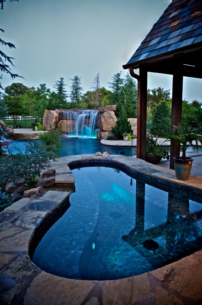 Inspiration for an expansive mediterranean backyard custom-shaped natural pool in Oklahoma City with a hot tub.