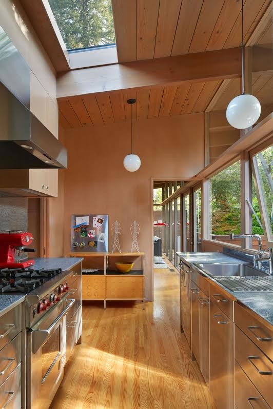 Design ideas for a small midcentury galley kitchen in San Francisco with a drop-in sink, flat-panel cabinets, stainless steel cabinets, medium hardwood floors and stainless steel appliances.